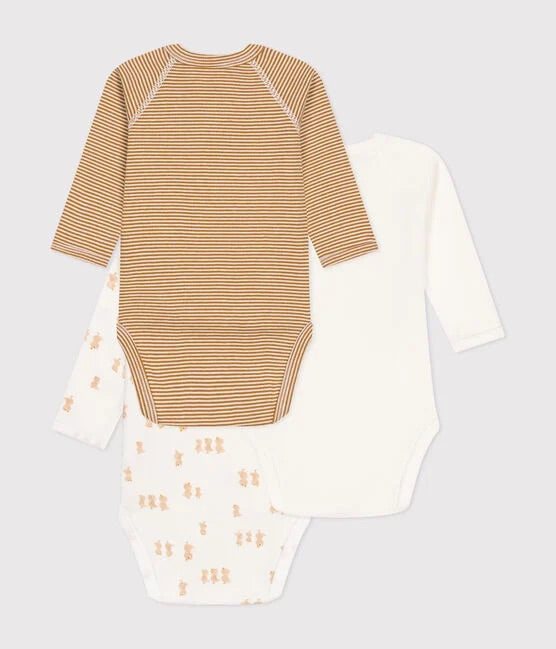 3 cache-couches superposés, un blanc à motifs, un blanc et un brun.