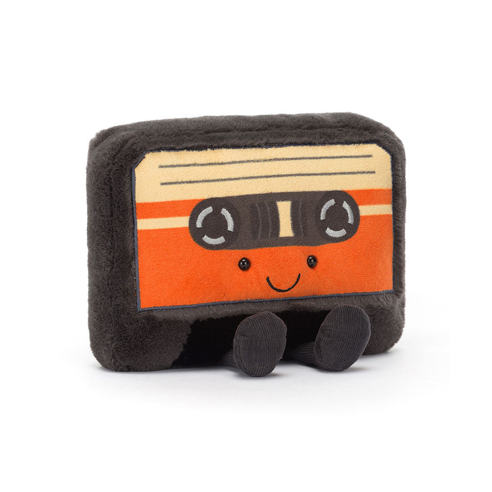 Peluche en forme de cassette retro orange avec un visage souriant et des jambes assises.