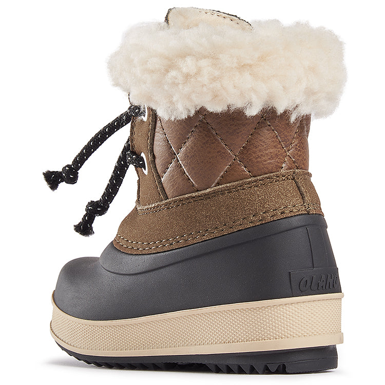 Une botte brune à la cheville et fourrure décorative blanche.