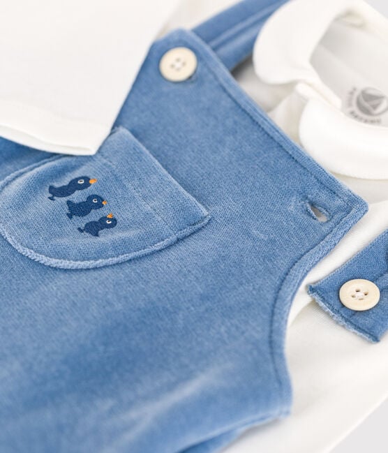 Une salopette bleu avec une poche à l'avant, des oisillons bleus brodés.