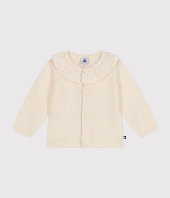 Un cardigan en tricot blanc avec col à petits volants.