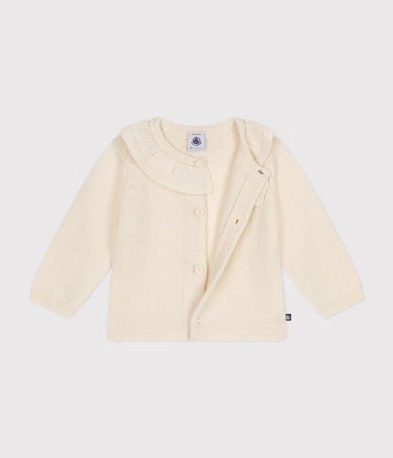 Un cardigan en tricot blanc avec col à petits volants.