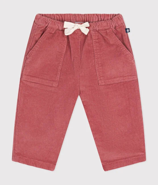 Un pantalon pour bébé en velours rose côtelé avec taille élastique et lacet blanc ajustable.