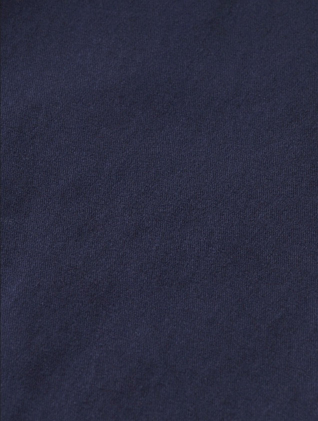 Détail de la texture d'un pantalon chino bleu marin.