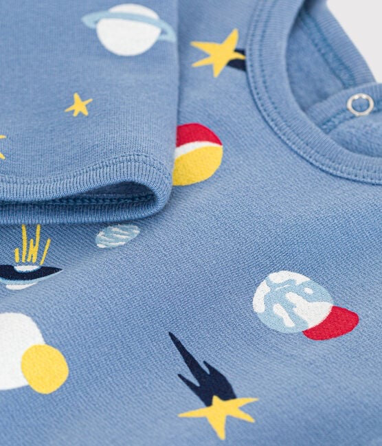 Un pyjama une pièce long bleu, avec motif d'illustration d'étoiles et de planètes.