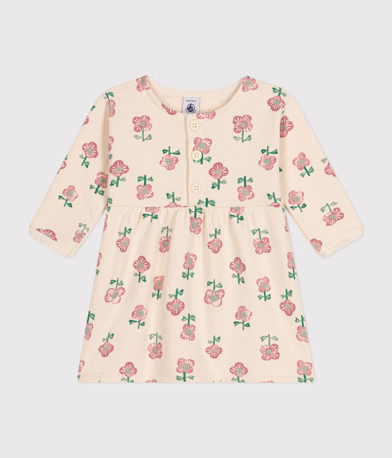 Une robe pour bébé à col rond et bouton à l'avant. Couleur crème et fleuri rose.