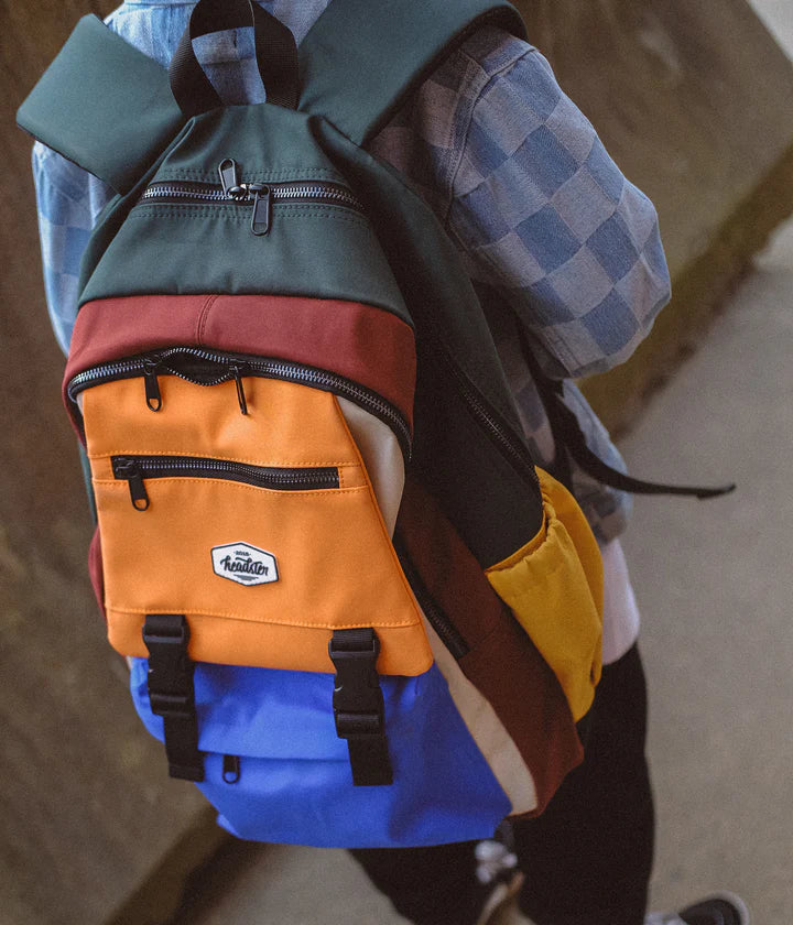 Un enfant portant un sac à dos blue, vert et orange.
