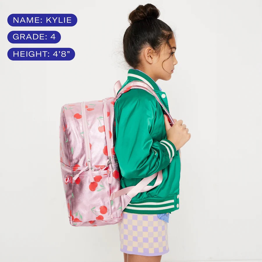 Une fillette mesurant 4'8'' portant un sa à dos couvrant l'entièreté de son dos.