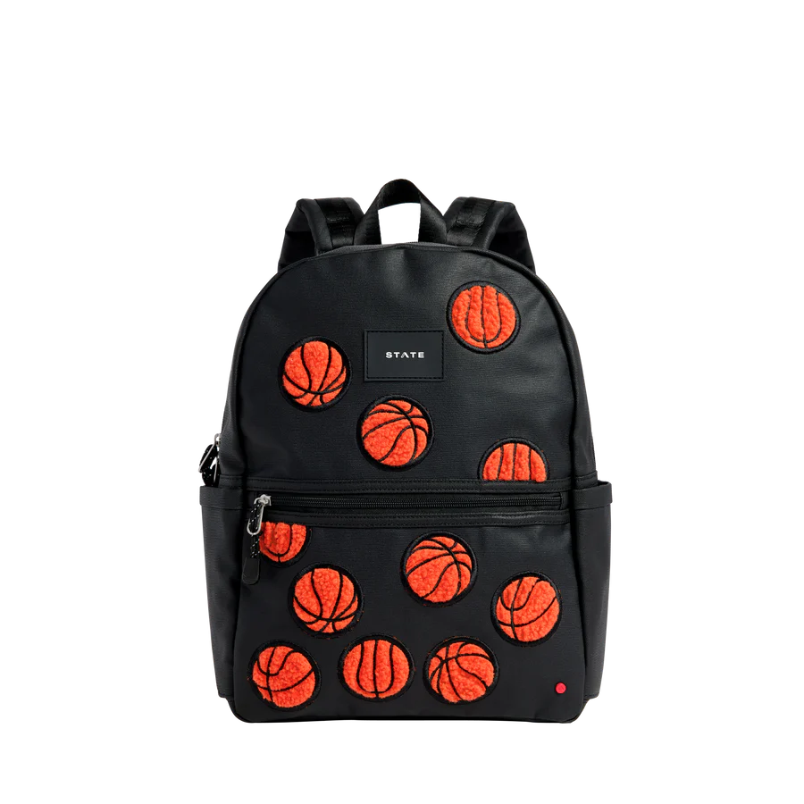Un sac à dos noir à texture de cuir avec patches de basketballs oranges sur l'avant.