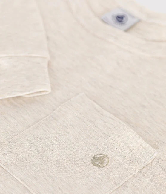 Un t-shirt à manche longue beige, avec une poche sur la poitrine droite.