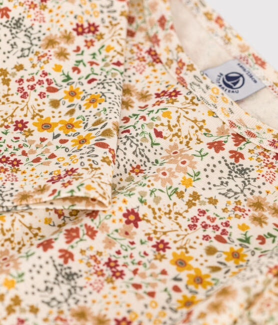 Un t-shirt à manches fleuri jeune, blanc et rouge, avec des volants sur les épaules.