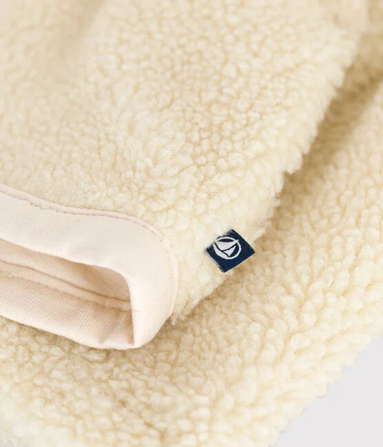 Une veste à manches longues et boutons à l'avant, en sherpa blanc.