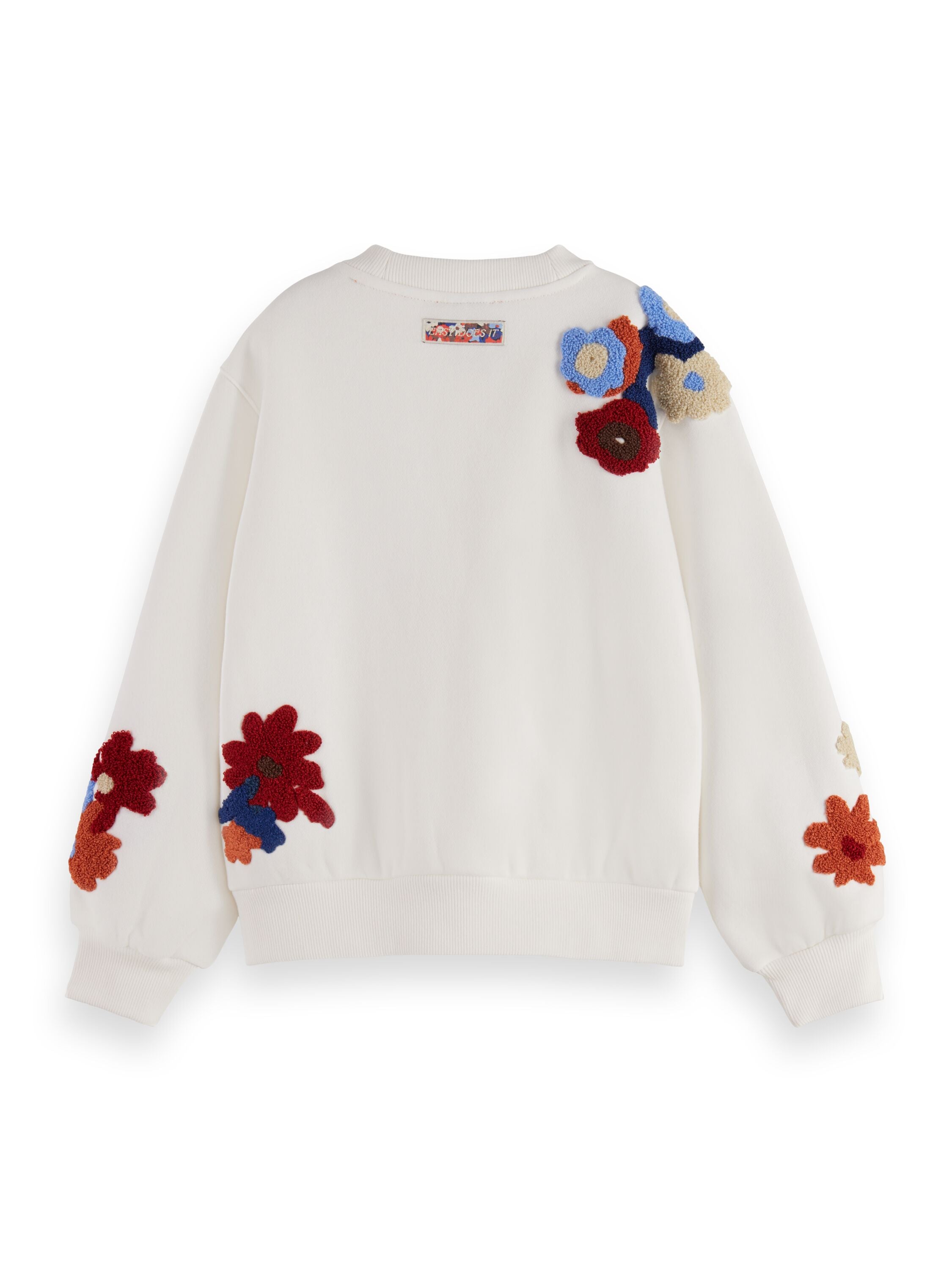 Un crewneck blanc avec des fleurs brodées sur la manche droite et le poignet gauche.