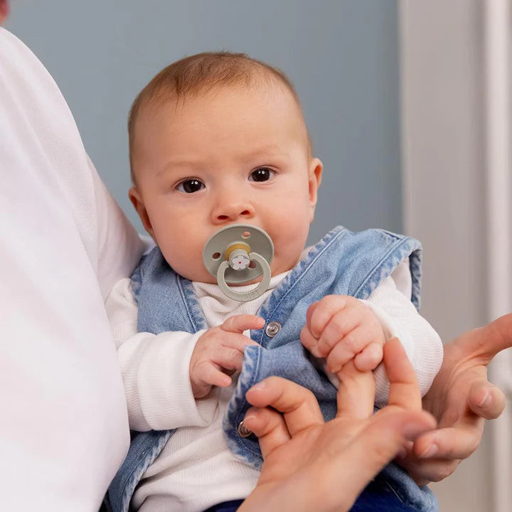 Un bébé utilisant une suce verte sage.