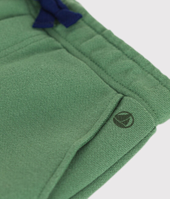 Un pantalon jogging vert à taille élastique et lacet ajustable noir, avec poches.