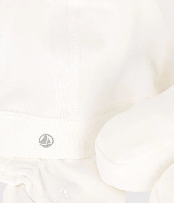Un petit logo Petit Bateau brodé sur de la laine blanche.