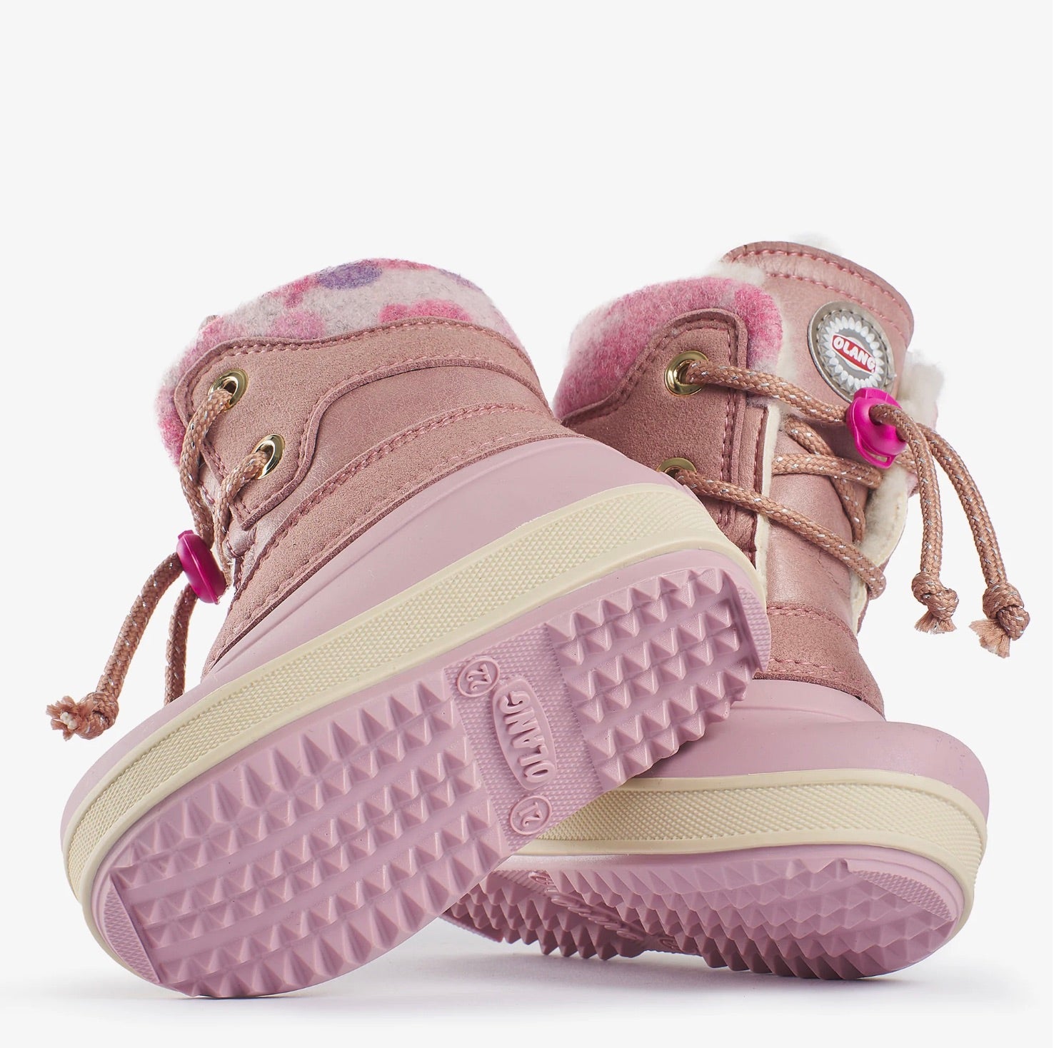 Une paire de bottes d'hiver rose courte avec lacets et fourrure blanche.