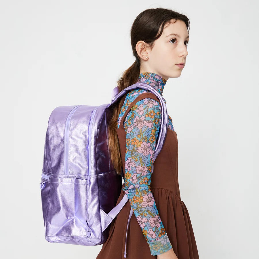 Une jeune fille portant un sac couvrant son dos en entier.