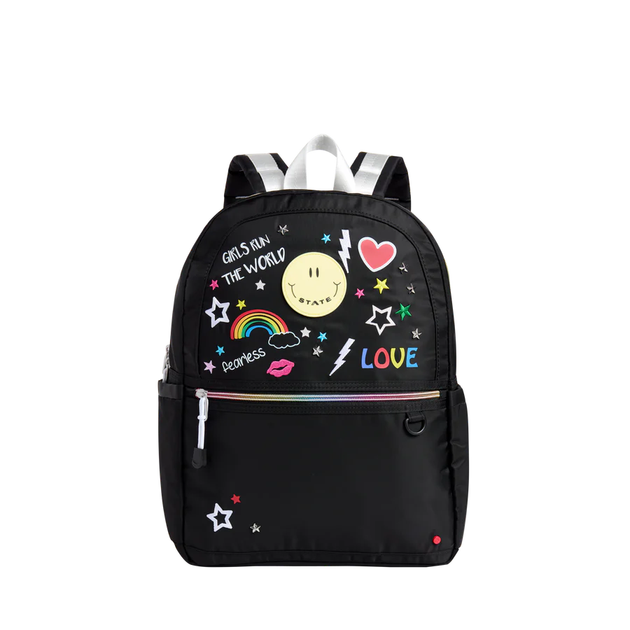 Un sac à dos noir avec des imprimés de dessins brouillons écolier colorés.