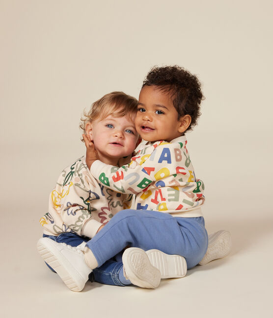 Un sweatshirt pour bébé beige avec un motif de fleurs dessinées colorées.
