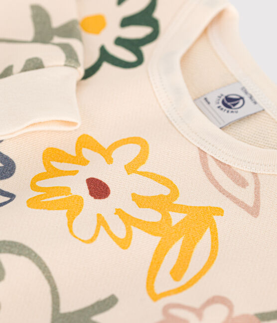 Un motif de dessins de fleurs jaune, rose et verte sur un fond beige.