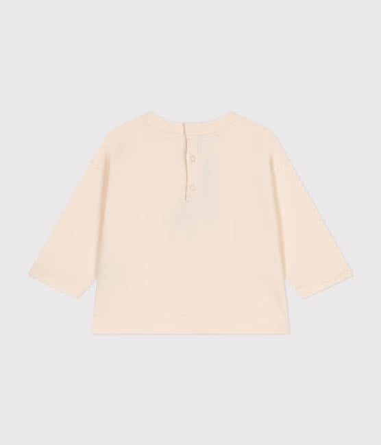 Un t-shirt beige avec boutons au dos.